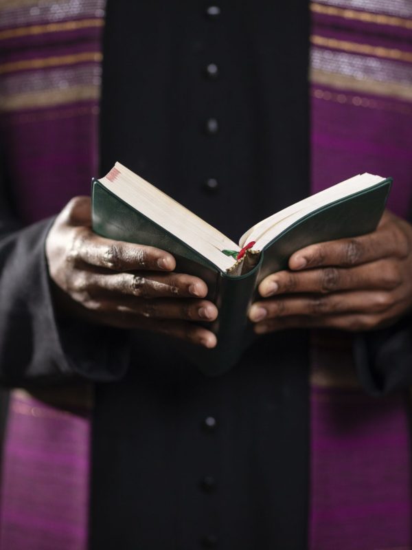 young-male-priest-with-bible-church-min